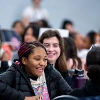 Girls of Color Summit previous event with a student giggling with friends